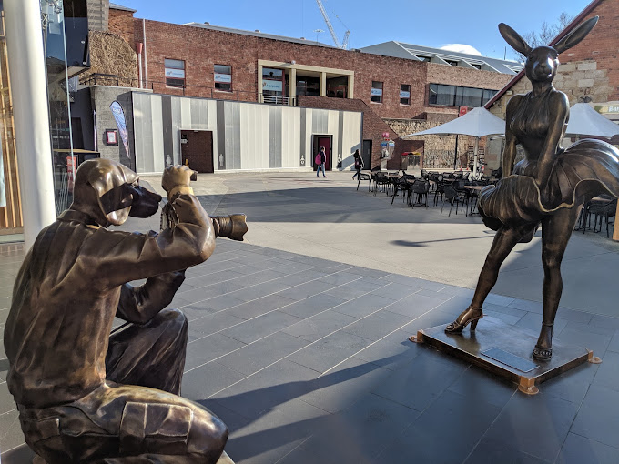 Bronze sculptures of a photographer and a rabbit-costumed figure in the courtyard at Salamanca Arts Centre