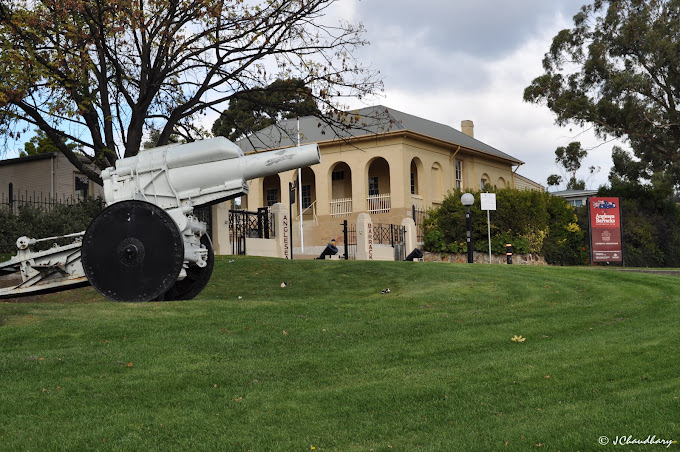 Historic sandstone building of the Army Museum of Tasmania with a decommissioned artillery gun on the lawn out front