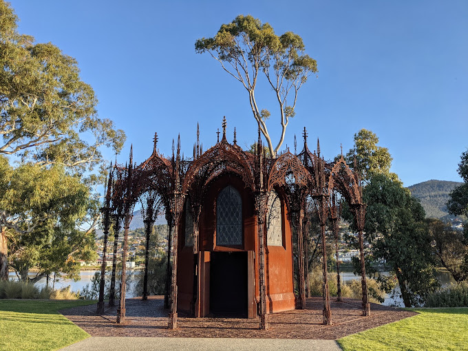 Ornate metal sculpture structure resembling a Gothic chapel on the lawn at MONA